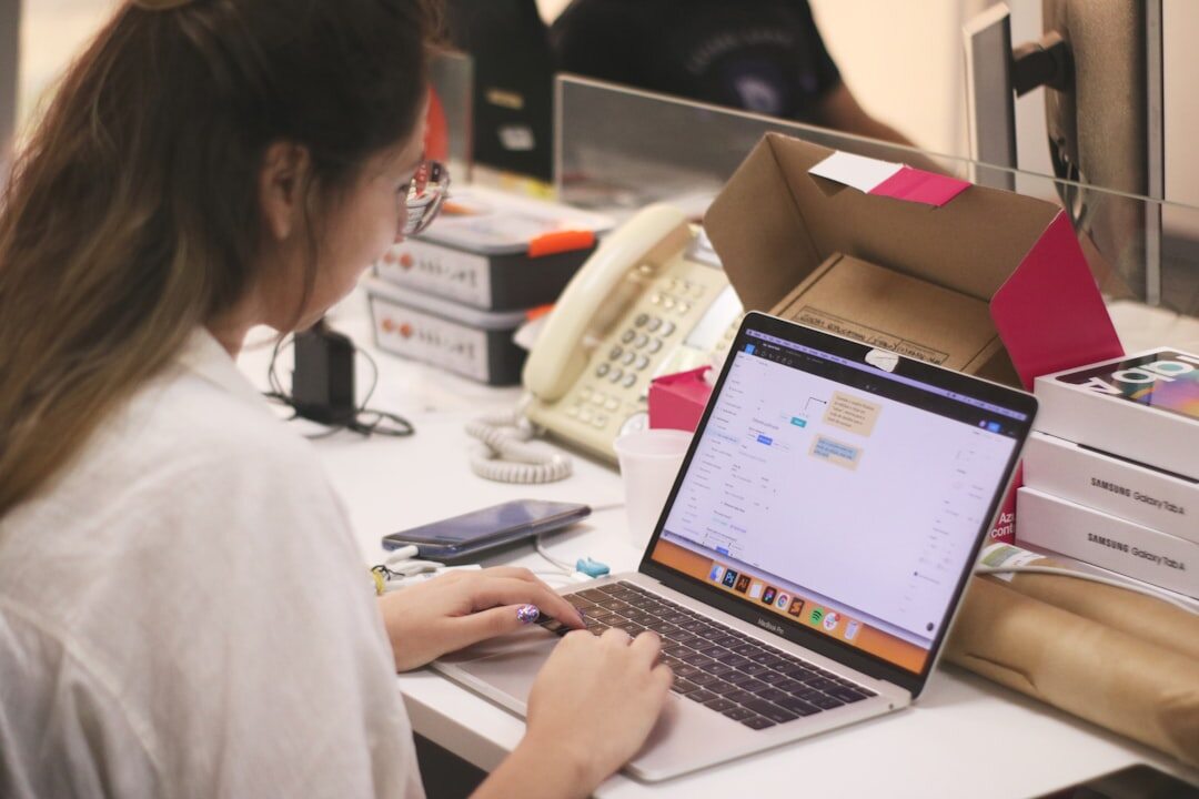 Journalist researching on laptop surrounded by notes and printed documents